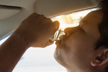 Man taking health drink while driving care for awake refreshment and robust drive - drive safe with some refreshment drink concept