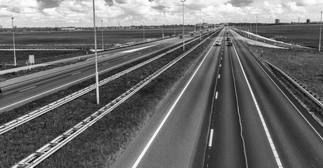 Interstate road in open countryside with blue car speeding up