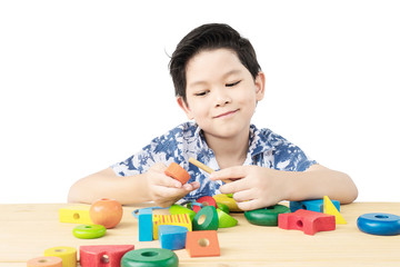 Lovely asian boy is play colorful wood block toy