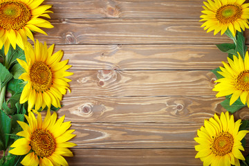 Beautiful sunflowers on a wooden table. View from above. Background with copy space.