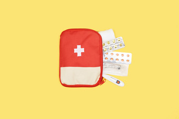 top view of automotive first aid kit with different medicines isolated on yellow