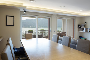 Wooden table with leather chairs with lake view window