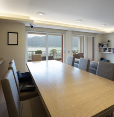 Wooden table with leather chairs with lake view window