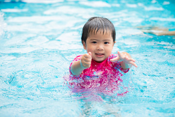 Fototapeta na wymiar Happy Cute Little girl in swimming pool. Summer outdoor.