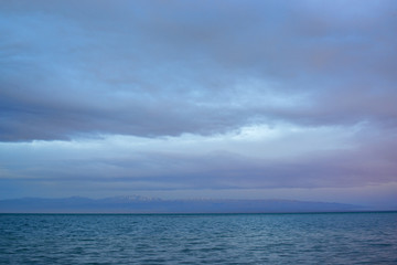Scenic view of lake with grey mountains on horizon
