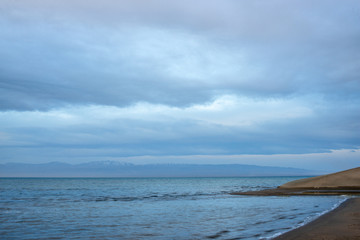 Scenic view of lake with grey mountains on horizon
