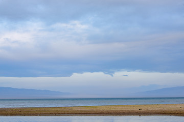 Scenic view of lake with grey mountains on horizon
