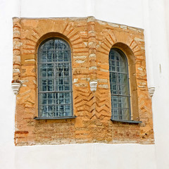 Two windows with bars in ancient brick wall/ Novgorod Kremlin, Russia.
