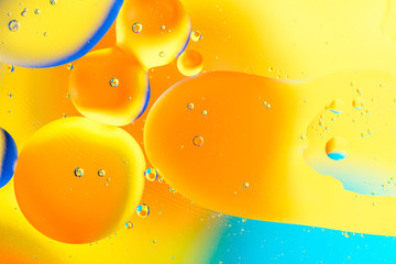 Beautiful color abstract background from mixied water and oil. Pastel colored abstraction. Yellow and blue background from water bubbles.
