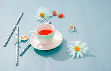 Morning cup of red tea on the table top view in flat lay pastel style .Beautiful breakfast and Daisy flower