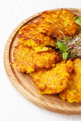 The concept of Ukrainian cuisine. Draniki from potatoes and pumpkins, with edible flowers. Copy space, selective focus