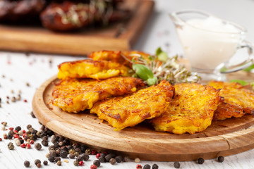 The concept of Ukrainian cuisine. Draniki from potatoes and pumpkins, with edible flowers. Copy space, selective focus