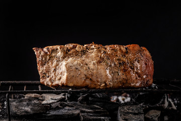 concept of the process of cooking meat. The steak is roasted on charcoal in a cast-iron frying pan, with spices, garlic, hot red pepper, squarish, thyme. image background. Copy space, selective focus