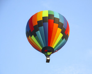 colorful hot air balloon against blue sky. hot air balloon is flying in white clouds. beautiful flying on hot air balloon