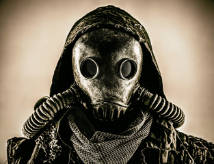 Close up portrait of nuclear post-apocalypse survivor, living underground mutant or creature, skilled stalker wearing rags and armored full-face gas mask or air breathing apparatus, toned shoot