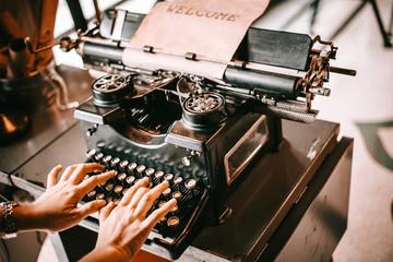 Old Typewriter antique or vintage Concept . Hands writing on old typewriter.