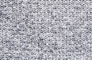 Cropped close up shot of seamless woolen knitting pattern of fall / winter season warm sweater, clearly visible fiber texture of stylish hipster knitwear clothing. Background, copy space, top view.