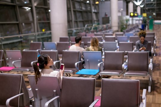 Woman Using Mobile Phone In Waiting Area