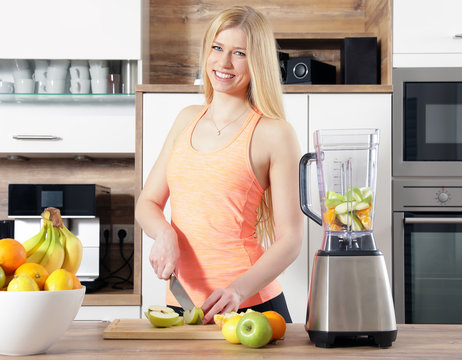 h&uuml;bsche blonde Frau m&auml;dchen macht einen smoothy mit einem mixer in der K&uuml;che