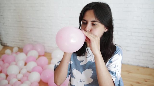 Girl blowing a balloon.