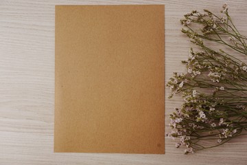 paper craft and dried flowers on wooden background