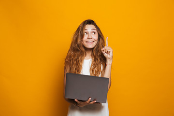 Portrait of a cheerful young girl holding laptop - obrazy, fototapety, plakaty