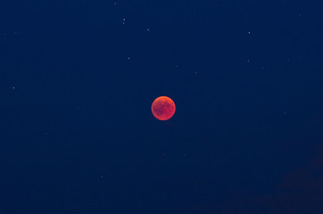 Total lunar eclipse on the evening of July, the 27th 2018 with red moon and stars ín the blue sky