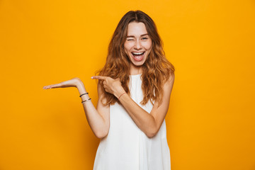 Portrait of a cheerful young girl pointing away