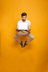 Full length portrait of a shocked young man jumping