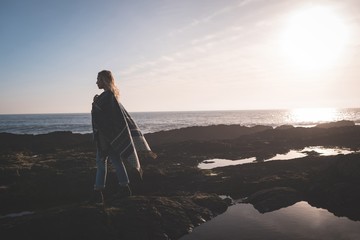 Woman walking over rock on a beach