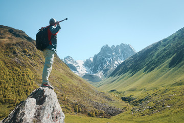 Hiker with Backpack and trekking sticks look view of the Chauhi mountain range in Georgia (country).