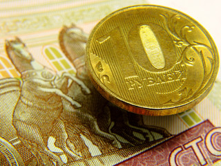 The Russian coin lies on the Russian banknote. Close-up.