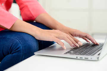hands finger nails closeup detail of a beautiful young woman on laptop computer keyboard