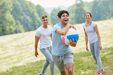 Freunde spielen zusammen Ball