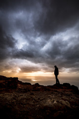 silhouette of a person on a rock