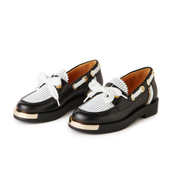 Elegant black and white loafers shoes with golden details. Studio shot, white background