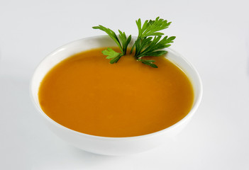 Pumpkin soup served in a bowl on white background