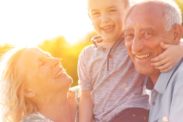 Grandparents with grandson enjoying time together in park.