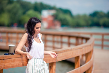 Happy young urban woman drinking coffee in european city.