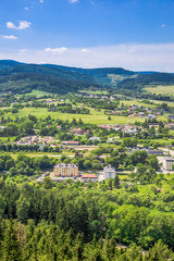Fototapeta na wymiar Aerial view of countryside scenery in the valley with green town and houses on foothills