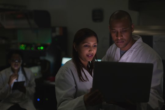 Scientists working over laptop in laboratory