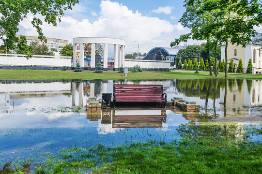 Bench surrounded by water in city park