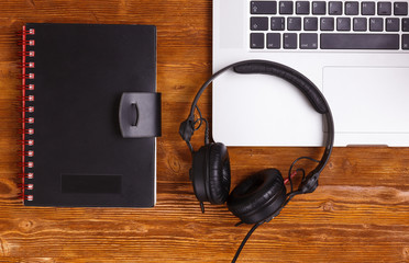 top view laptop headphones diary book on wooded table