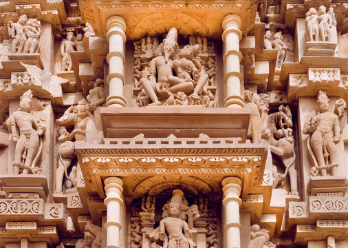 Indian architecture with figures of Lord Shiva and wife Parvati. Reliefs of historical temple in Khajuraho. UNESCO Heritage site, India