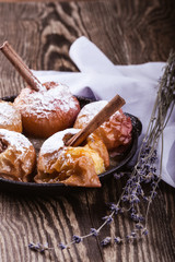 Baked apples with cinnamon sticks in cast iron skillet