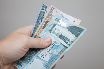 Male hand holding Jordanian dinars