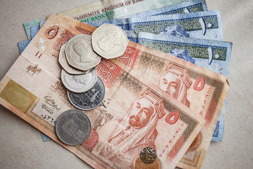 Jordanian dinars and piastres on gray paper