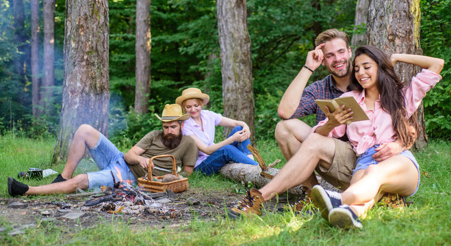 Couples or families having great time relaxing near campfire. Couples spend time outdoors on sunny day. Pleasant weekend. Youth on picnic or hike relaxing and having fun. Couples tourists rest forest