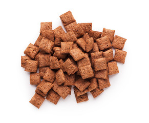 Pile of chocolate pillow cereals on white background
