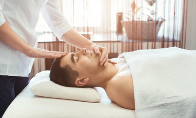 Obraz na płótnie Canvas Handsome man getting professional facial massage
